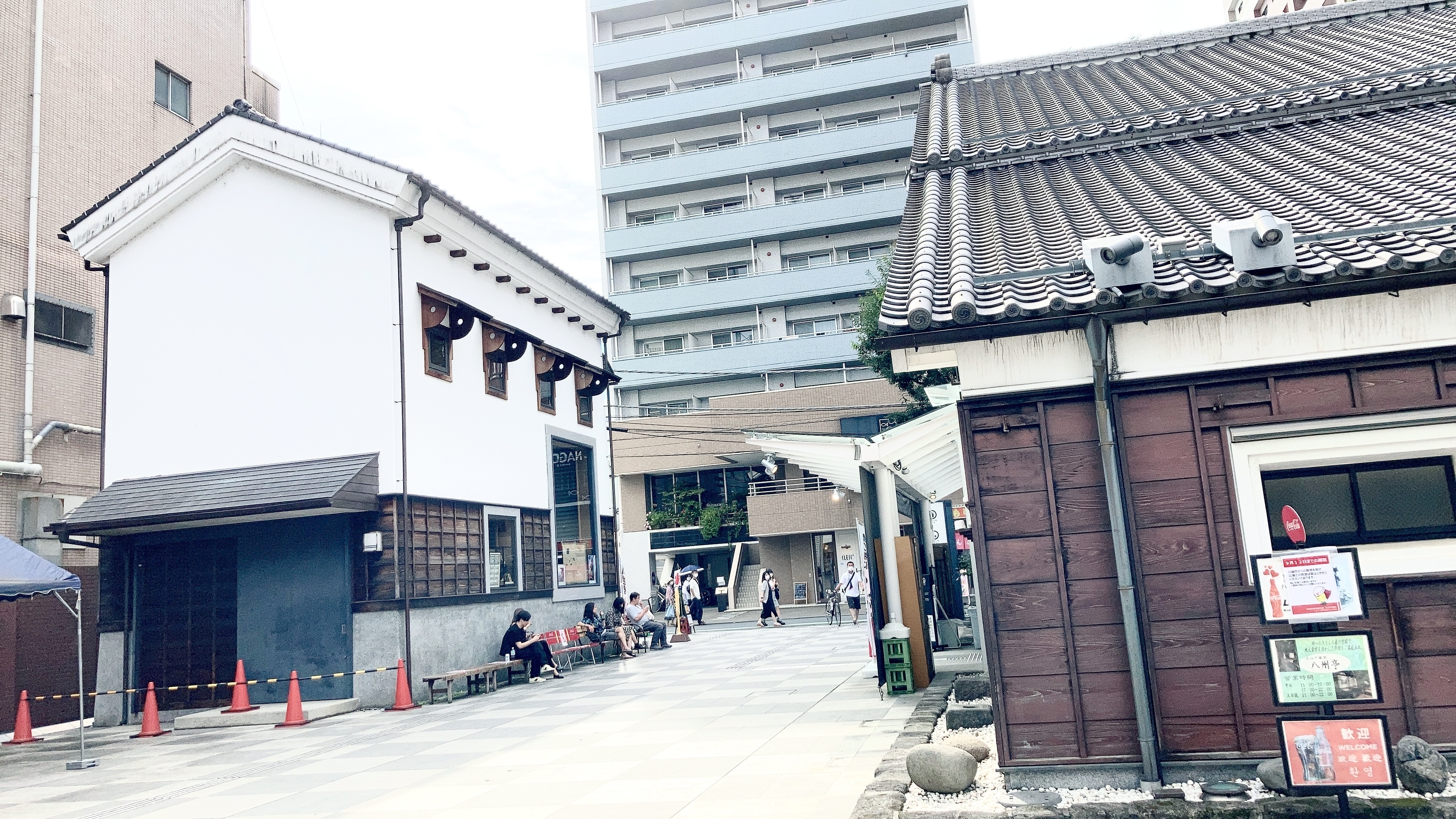 左右に和風建築が一軒ずつ、奥にビル。