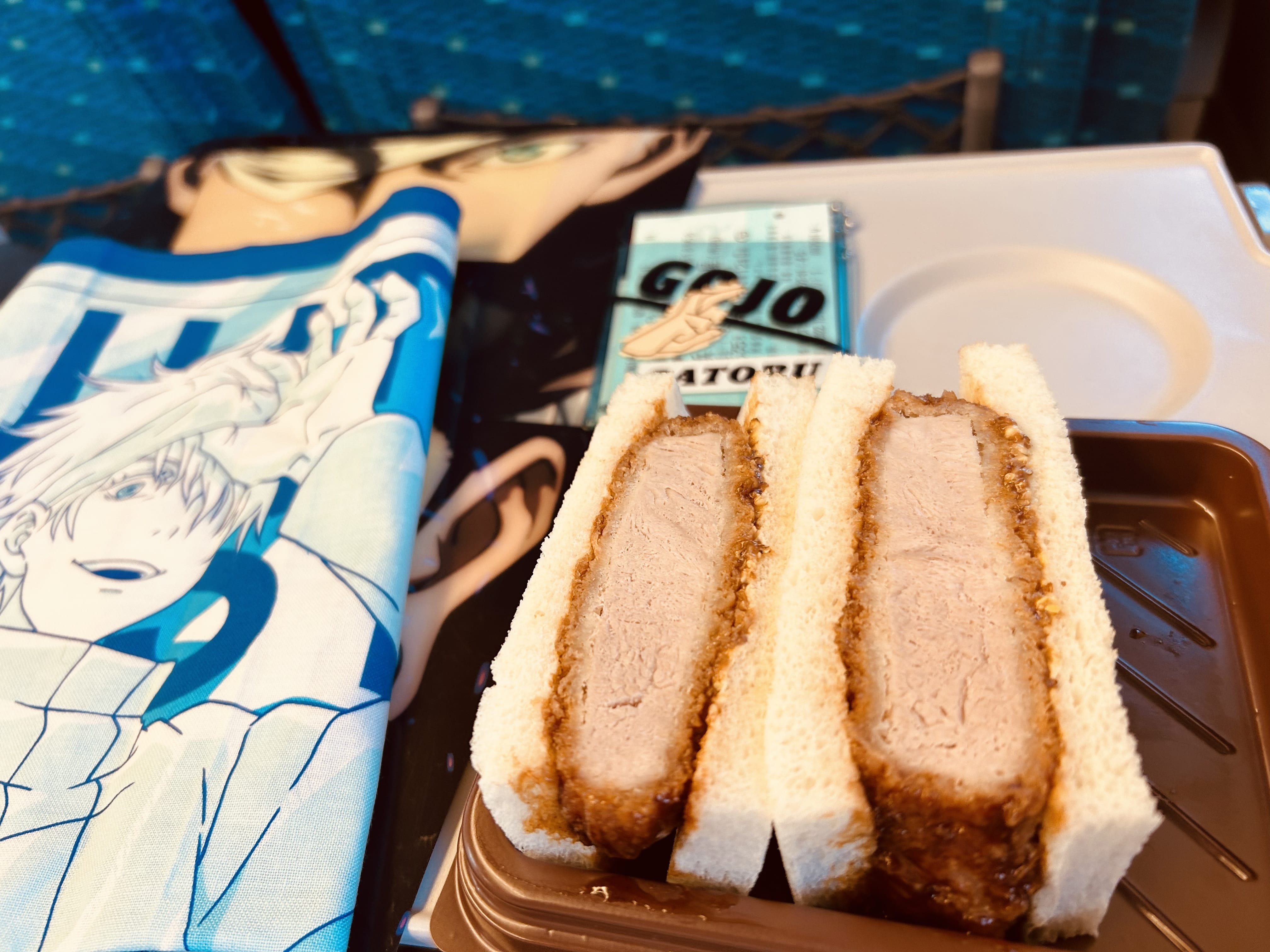 新幹線の車内　五条悟のグッズとカツサンド
