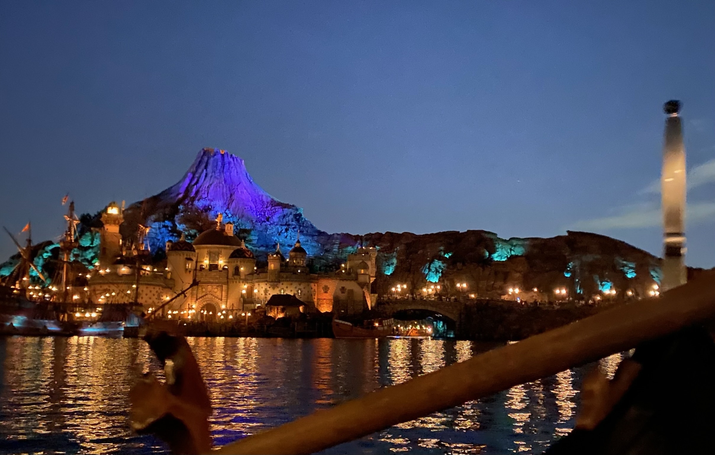 ディズニシーの夜景。ゴンドラから見た景色です。人気アトラクション「センター・オブ・ジ・アース」が奥に見えます。その手前にはライトアップされた建物が見えます。水面には、光が反射して綺麗です。