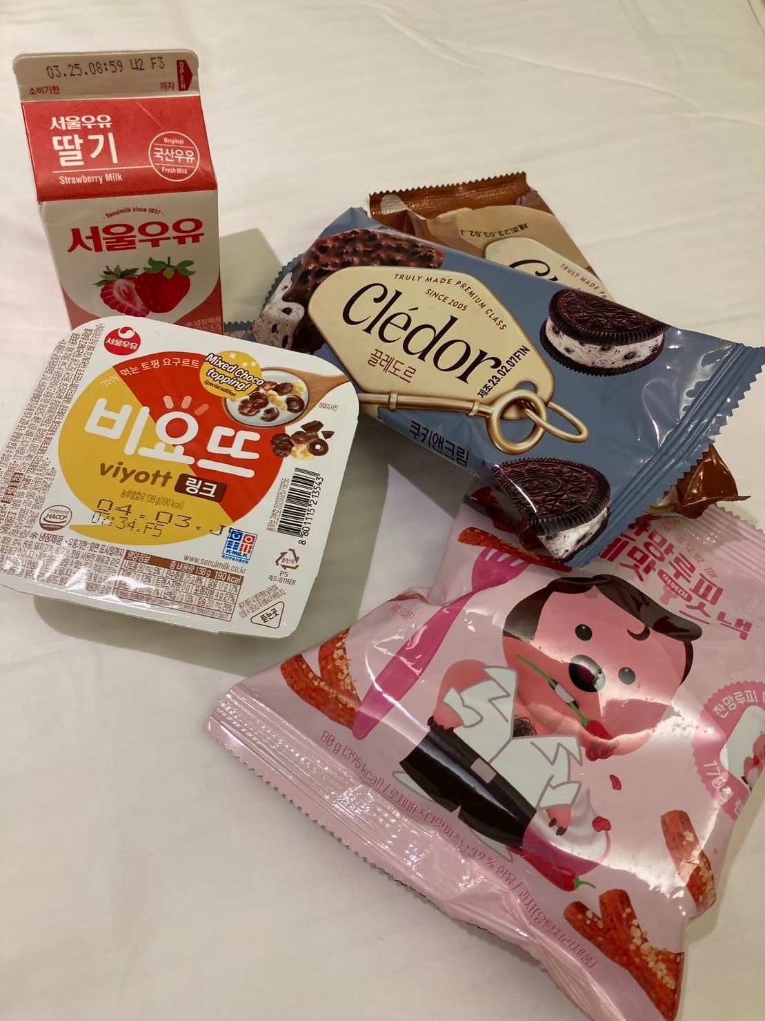 コンビニで買ったお菓子やヨーグルト、ジュース、アイスの写真
