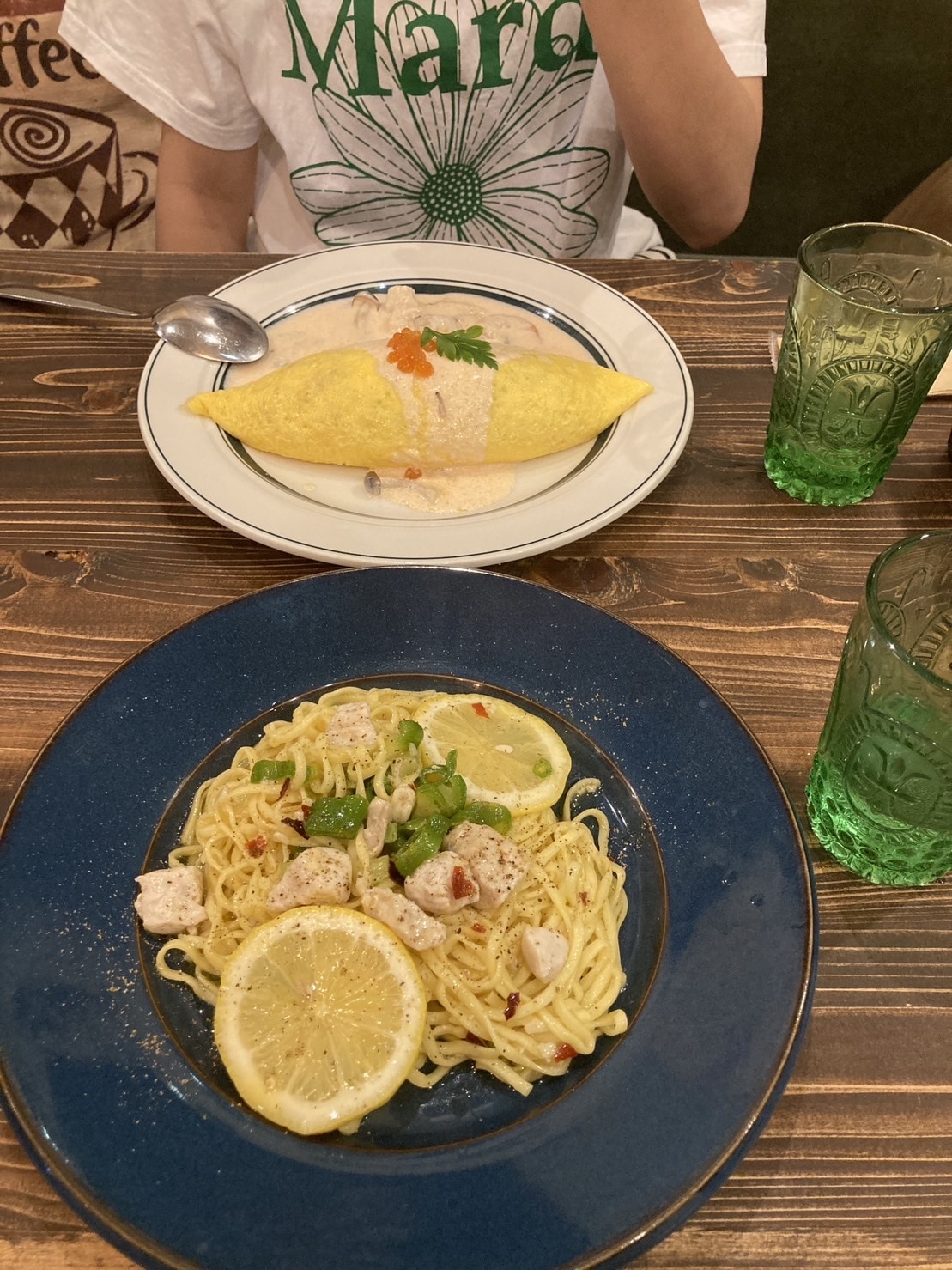 オムライスとパスタの写真。パスタにはレモンが乗っている。