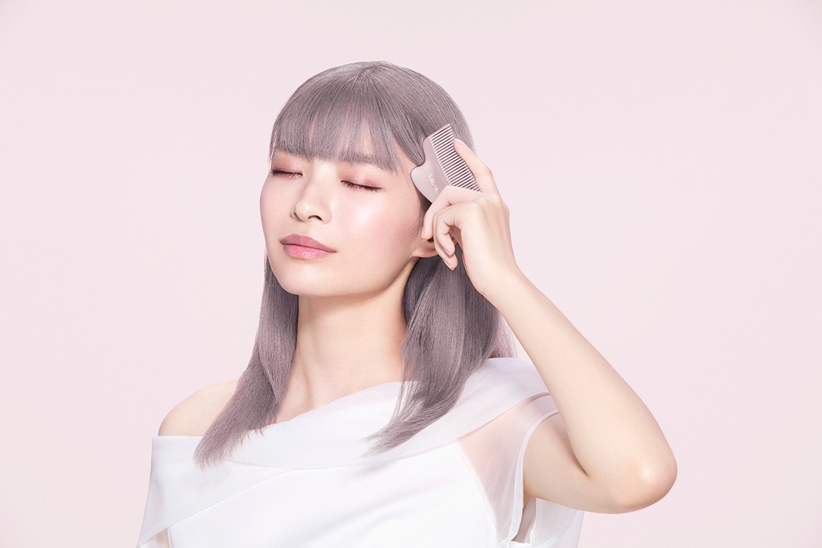 かっさで頭皮ケアをしている女性